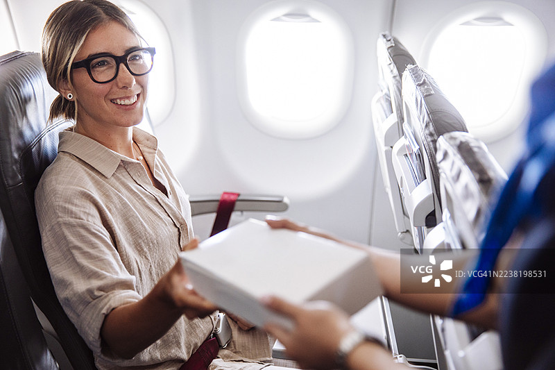 飞机上，乘客在飞行途中接受机上服务图片素材