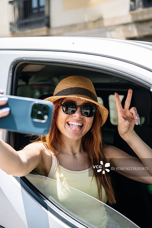 快乐的女人在巴塞罗那的旅行中，在面包车里自拍图片素材