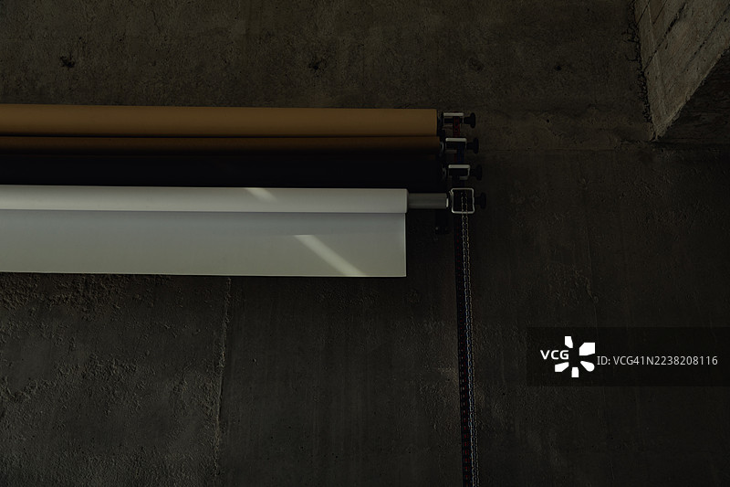 棕色和白色的卷轴背景布特写，安装在混凝土墙上。图片素材