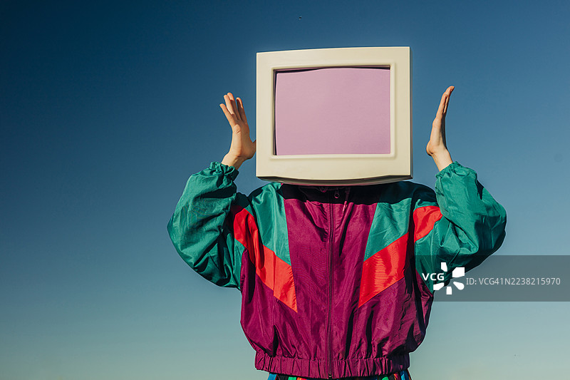 穿着90年代风格运动服的人头上戴着复古CRT显示器，户外场景图片素材