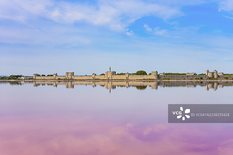 法国加尔省艾格莫尔特中世纪城镇及其在粉色盐沼中的倒影照片图片素材