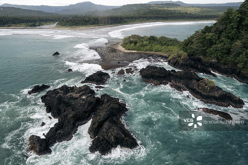 南尼亚斯，北苏门答腊，印度尼西亚的风景如画的海岸风光，有崎岖的岩石、茂密的绿植和拍打着海岸的绿松石色海浪。图片素材