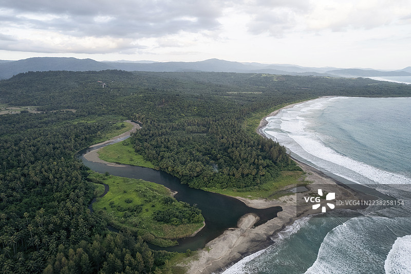 印尼北苏门答腊省南尼亚斯岛，郁郁葱葱的海岸线空中俯瞰，河流蜿蜒穿过茂密森林，最终汇入沙滩。图片素材