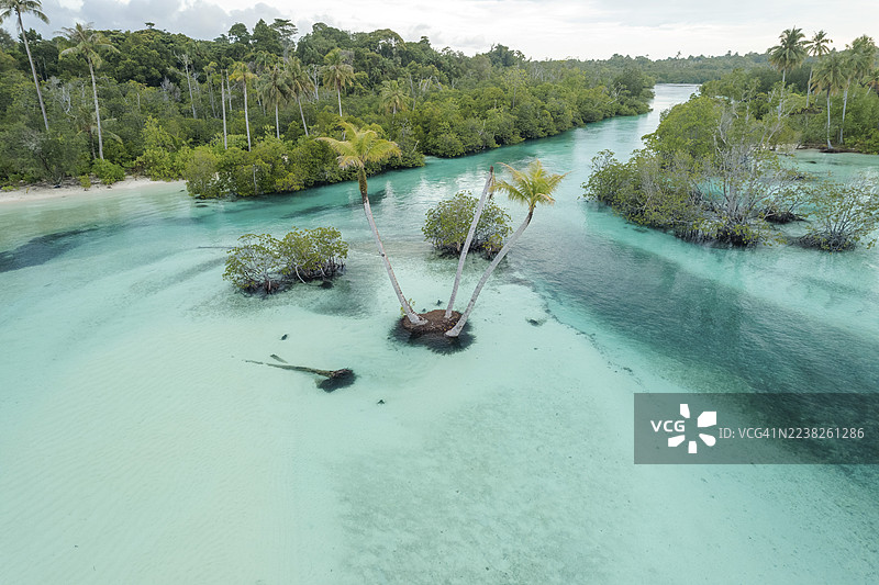宁静热带泻湖的鸟瞰图，拥有绿松石般的海水和郁郁葱葱的绿色岛屿。三姐妹棕榈树，明打威，西苏门答腊，印度尼西亚图片素材