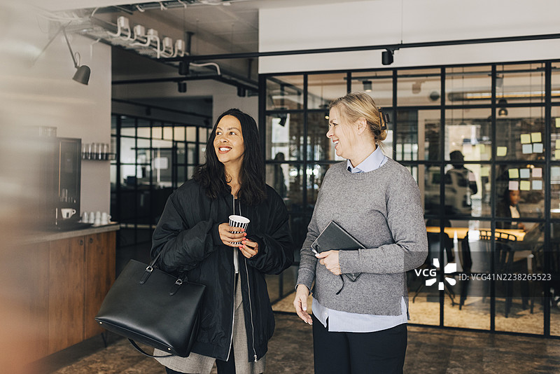 一位年长的女商人微笑着与新招聘的女员工在办公室交谈图片素材