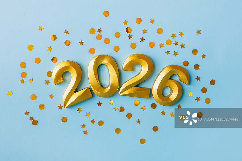 金色2026新年数字，背景为蓝色，撒满纸屑。新年庆祝派对。祝福与祝贺。图片素材