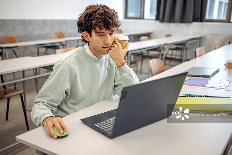 年轻人在大学学习，手中拿着咖啡杯图片素材