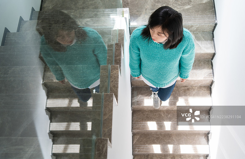 俯视女性在楼梯上行走，家中图片素材
