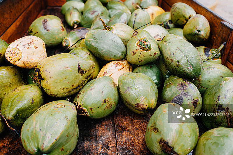 一个装满新鲜绿色椰子的木制手推车，营造出乡村热带风情图片素材