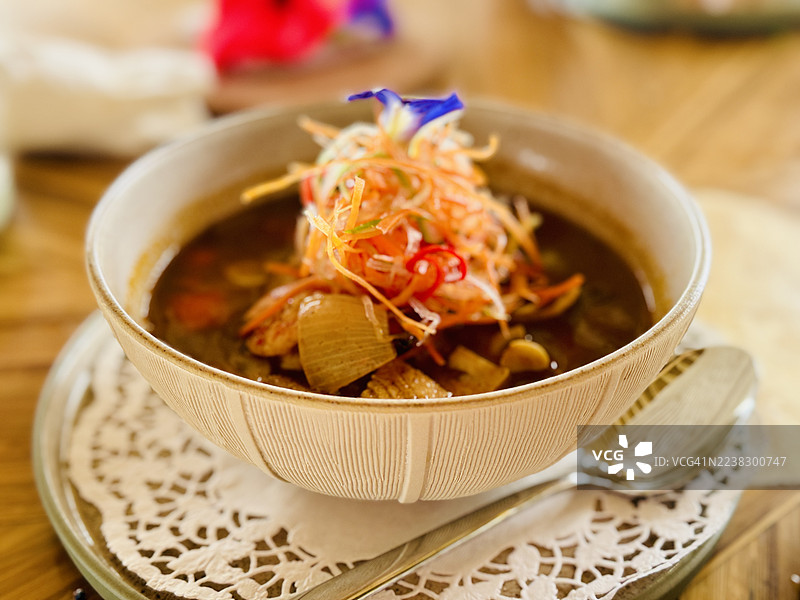 Rawon beef soup with shredded carrot garnish.图片素材