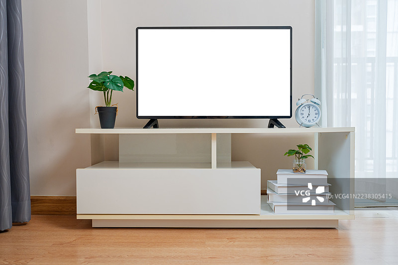 客厅里的电视机空白屏幕。白色墙壁背景下的橱柜上摆放着智能电视。现代白色架子上的平板电视在家中。图片素材