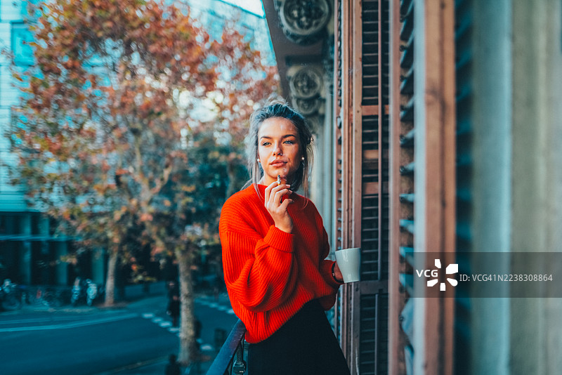 一名游客在巴塞罗那欣赏城市景观，同时享用咖啡和香烟。图片素材