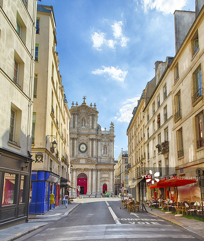 巴黎玛莱区圣保罗圣路易教堂，周围有带户外露台的餐厅和小型商店，以及历史建筑图片素材