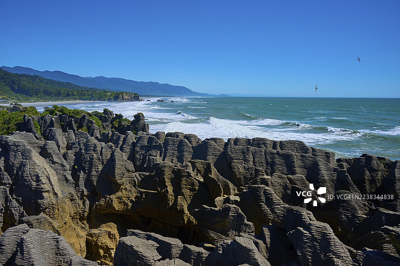 广阔天空下的巨浪拍打着层叠的壮观悬崖，薄饼岩，韦斯特波特，格雷茅斯，西海岸，南岛，新西兰图片素材