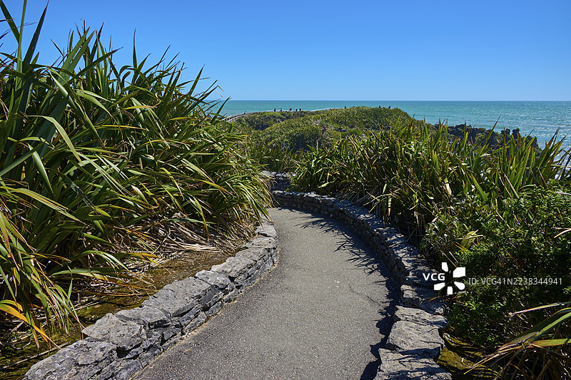 新西兰南岛西海岸韦斯特波特和格雷茅斯附近的薄饼岩，沿绿色风景中的蜿蜒道路可欣赏海景。图片素材