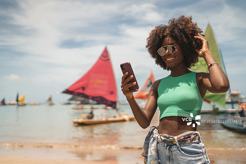 黑人青年在加利尼亚斯港海滩上自拍图片素材