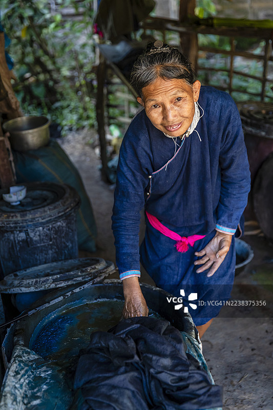 老挝北部村庄里的老挝妇女正在检查刚染好的布料图片素材