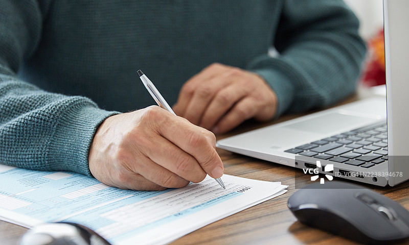 特写：双手填写财务或税务文件图片素材