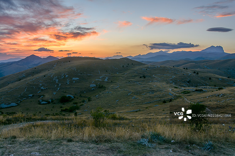 意大利格兰萨索山脉，夕阳下的连绵山丘与远山，宁静而辽阔的景观图片素材