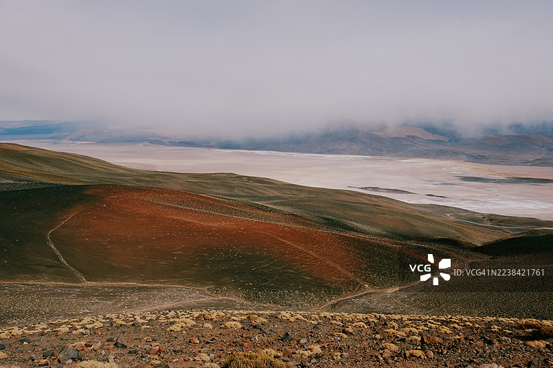 干涸湖床和蜿蜒小径的干旱山区景观的戏剧性高角度视图，多云天空下，阿根廷，安托法拉盐沼图片素材