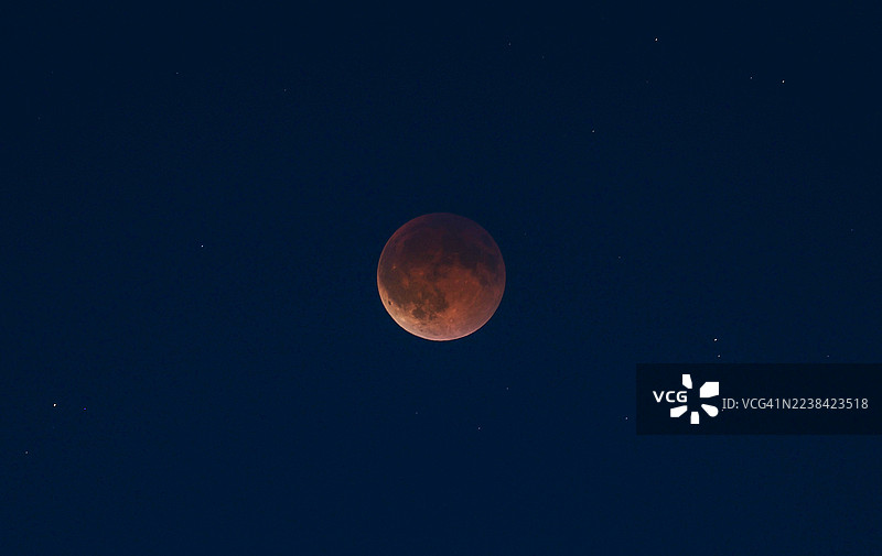 血月月食，背景为可见星星的黑暗夜空图片素材