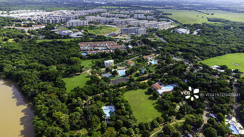 高角度视图，俯瞰繁茂的绿色城市，内有建筑和河流。图片素材