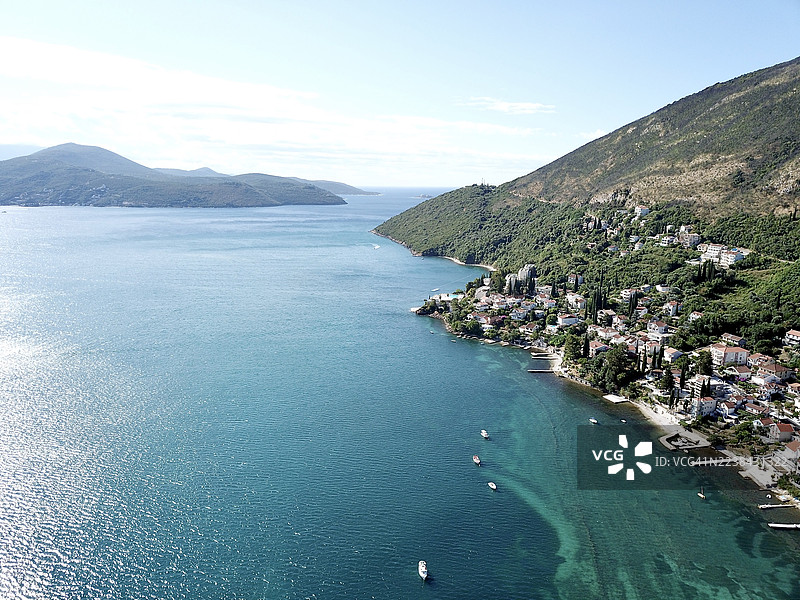 黑山，赫尔采格诺维，从高处俯瞰亚得里亚海美丽海岸线，郁郁葱葱的绿山脚下坐落着迷人的村庄，天空湛蓝。图片素材