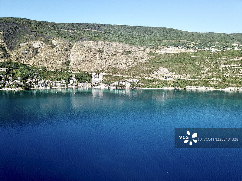 碧空下的海滨小镇全景与宁静的蓝色湖泊图片素材