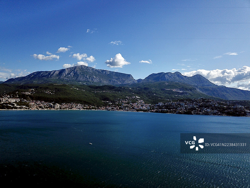 黑山，海尔采格诺维，群山环抱、深邃蓝海下的海岸小镇全景，天空晴朗图片素材