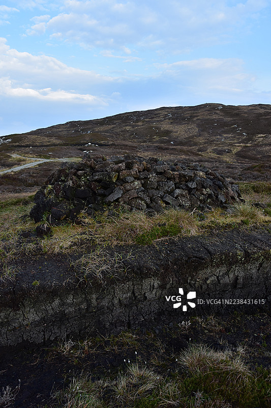多云天空下的粗犷石砌建筑景观，展现了大自然的原始之美图片素材