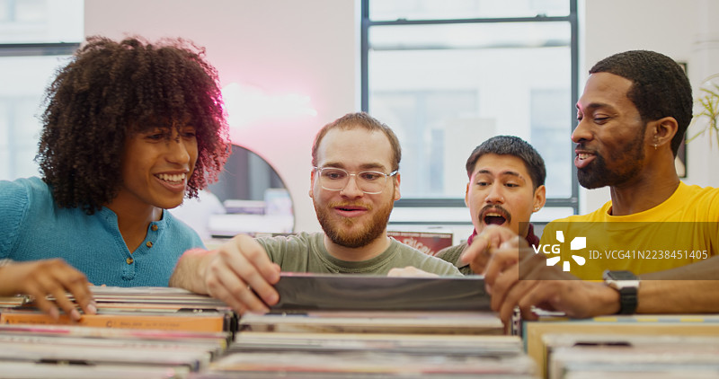 四个朋友在纽约布鲁克林的一家唱片店里玩乐图片素材