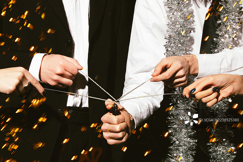 朋友们在节日庆典上一起拉响礼花筒图片素材