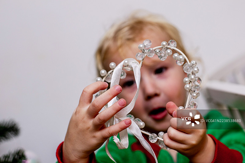 可爱的学步幼儿正在看闪闪发光的圣诞装饰品图片素材