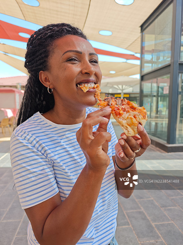 户外快乐女人咬披萨图片素材