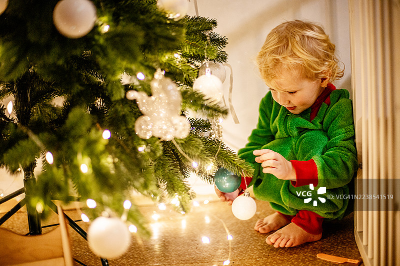 可爱的幼儿看着闪闪发光的圣诞装饰品图片素材