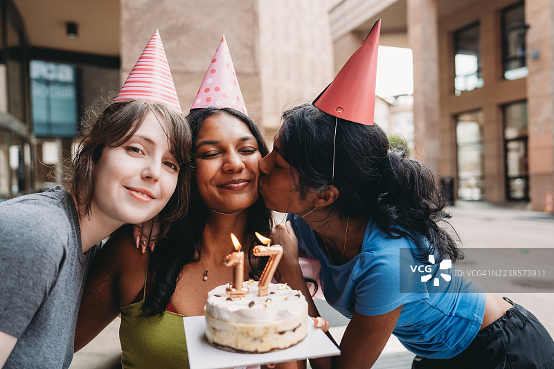 青少年朋友们在生日派对上庆祝，有蛋糕和蜡烛。图片素材