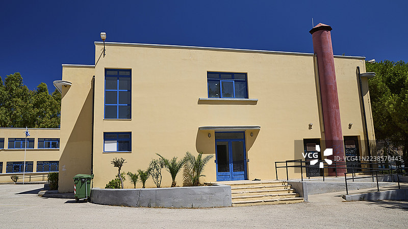 希腊拉科斯莱罗斯多德卡内斯群岛的波托拉戈历史主义装饰艺术理性主义现代米色体育馆,蓝色门窗,晴空万里图片素材