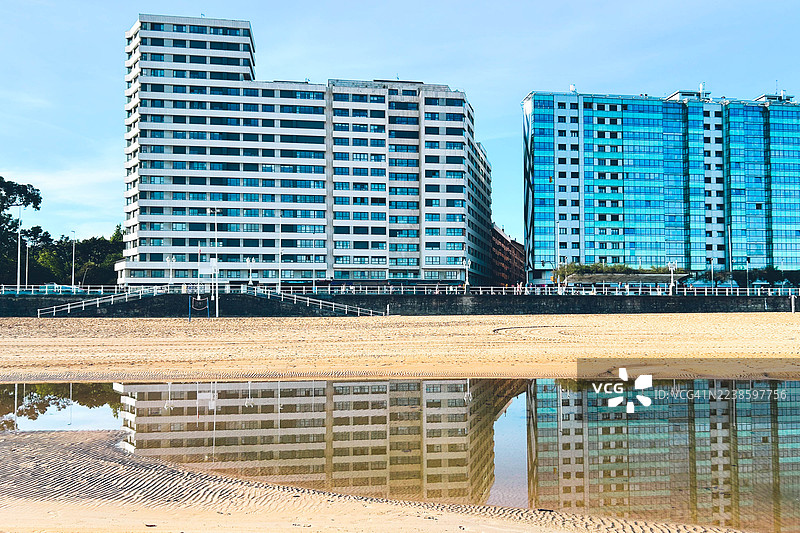 Residential buildings reflected on the beach图片素材