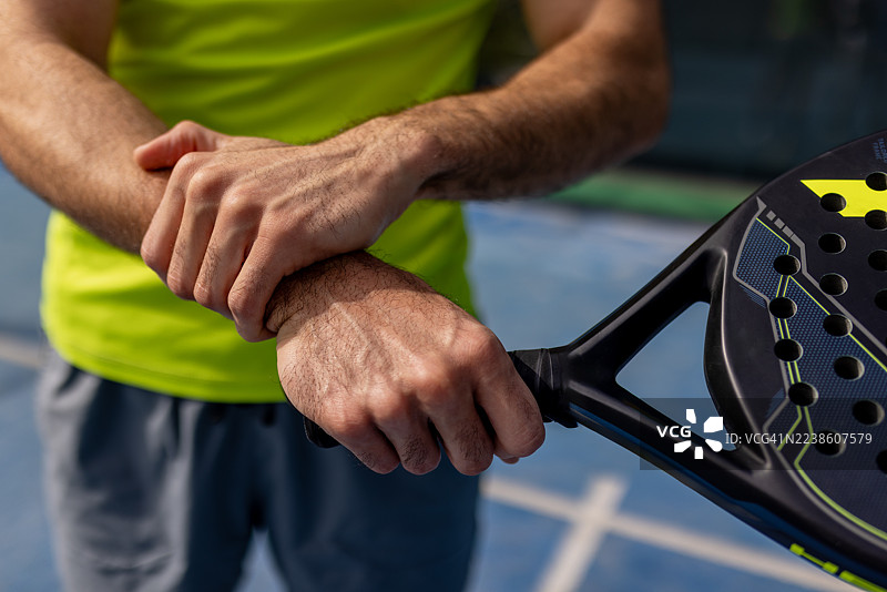 运动损伤：一名男性板式网球运动员在场上遭受手腕不适图片素材