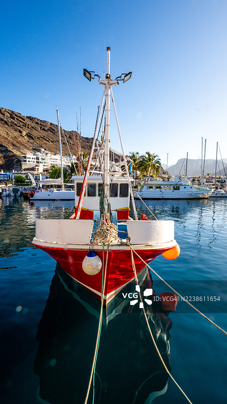 停泊在港口的艺术渔船，水清如蓝，倒影清晰图片素材