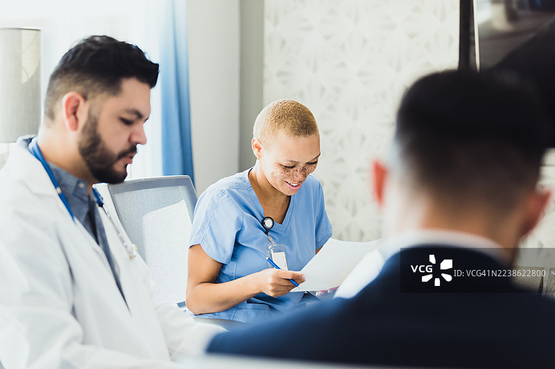 医护人员在会议中协作，讨论患者图表和病历。图片素材