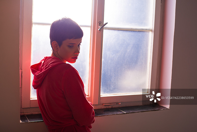 年轻的癌症女患者站在医院窗边图片素材