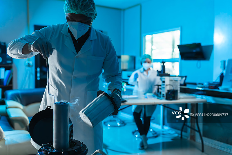 身穿防护装备的科学家在农业实验室中操作液氮，在生物技术实验室进行精子储存，确保在牛育种计划中的质量控制。图片素材