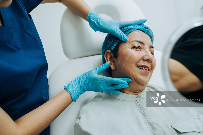 女性患者在诊所与医生评估脸部提升的可能性图片素材