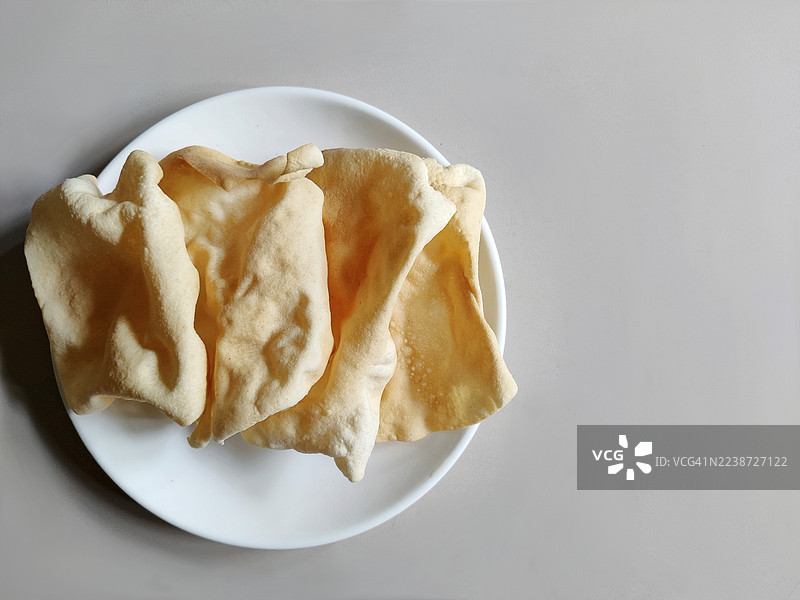 特写：白色陶瓷盘/白色背景/喀拉拉邦的自制油炸酥脆的Pappadam/papadum/poppadom/appalam图片素材