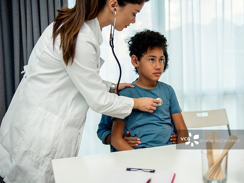女医生用听诊器检查小男孩病人图片素材