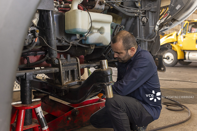 男性技师在工业车间修理卡车图片素材