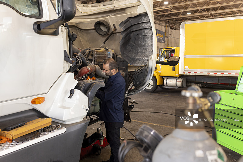 汽车修理工在商业车间内修理卡车发动机图片素材