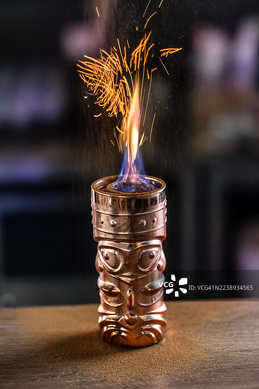 一款热带TIKI朗姆酒鸡尾酒，酒精含量高，制作时会燃烧，撒上肉桂粉在火焰上产生美丽的火花。图片素材