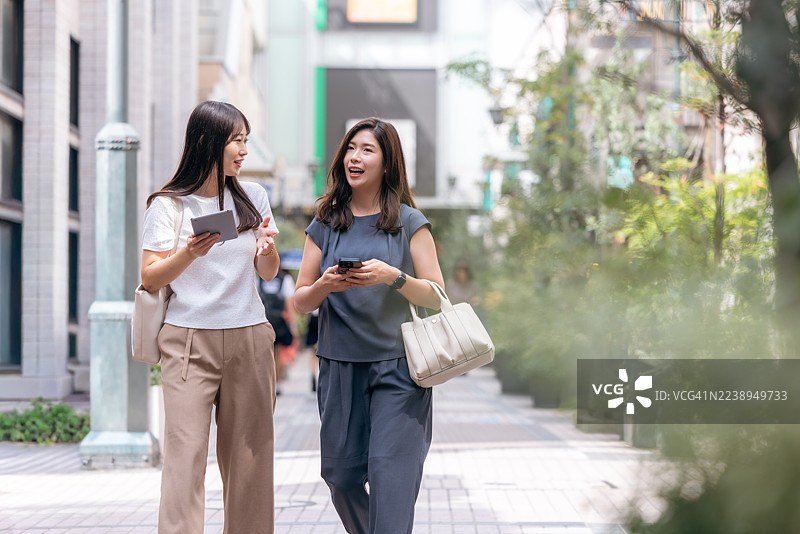 女商人在城市中边走边谈图片素材